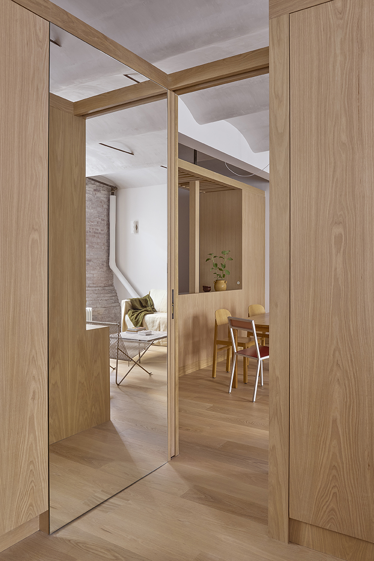 Bedroom enclosed by custom millwork and reeded-glass pocket doors